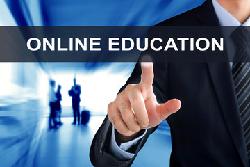 Businessman hand touching ONLINE EDUCATION tab on virtual screen
