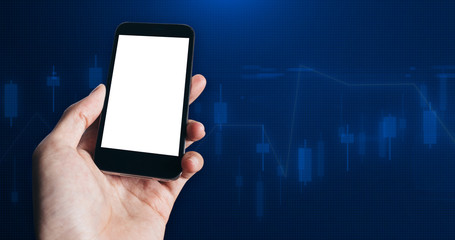 Close up of Businessman hand holding smart phone with Blank White Screen on Stock market financial analysis indicator background
