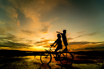 Obraz premium silhouette of bicycle and people with sunset background