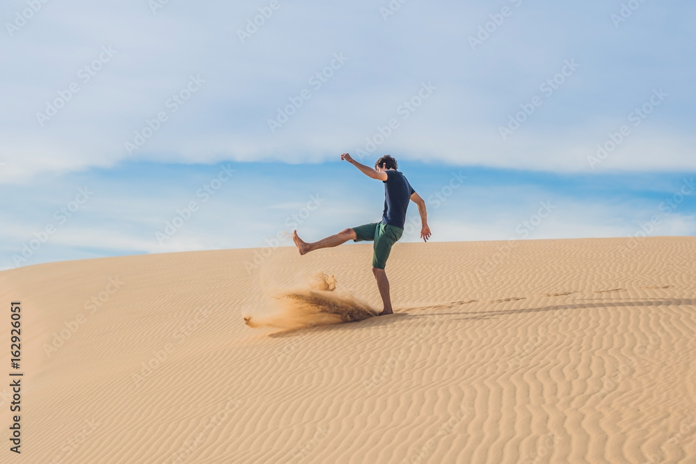 Wall mural man kicks the sand, annoyance, aggression