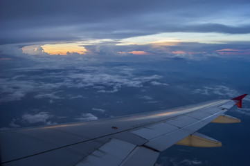 Fototapeta na wymiar Through the windows of an airplane overlooking sunset on high altitude.