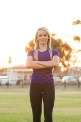 Fototapeta premium Athletic female fitness model posing in her training clothes next to a tartan athletics track