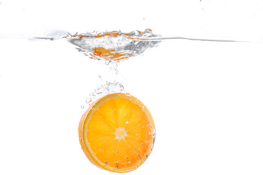 orange slice in water splash. white background © eplisterra