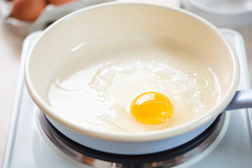 Egg fried on vegetable oil on blue pan 