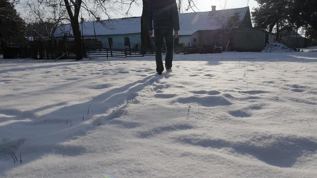 The man walks away in the snow. The countryside in winter

