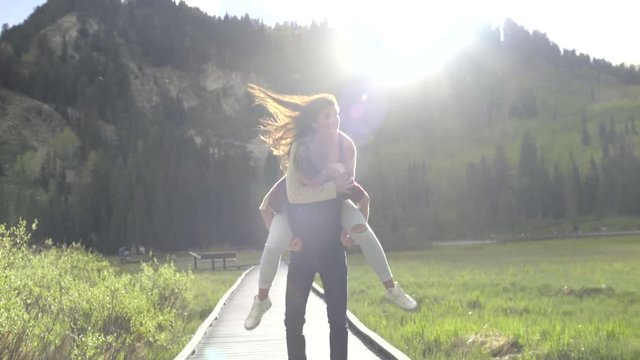 Teenage Boy Gives Girlfriend A Piggyback Ride, Twirls Around, Then Runs, She Covers His Eyes (Slow Motion)