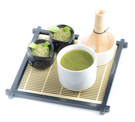 Green matcha tea in a bowl and bamboo whiskon, isolated on white