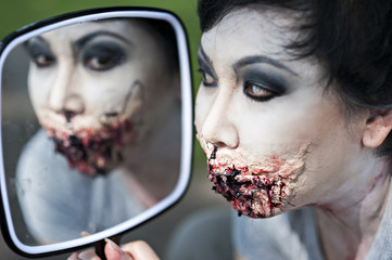 Make-up face art for Halloween party, broken lips effect with paper and fake blood.