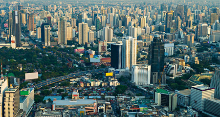 City scape with modern skyscrapers and express way against with slum houses in front of. Bangkok aerial view evening panorama
