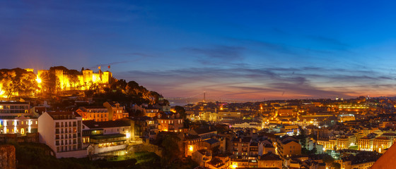 Panorama with Castle of Sao Jorge, the historical centre of Lisbon, Tagus River and 25 de Abril Bridge during evening blue hour, Lisbon, Portugal