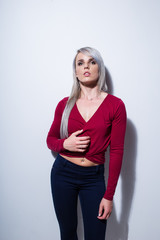 Sexy female fitness model in a studio with dramatic lighting and sexy outfit