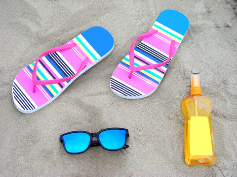Colorful flip-flops, sunglassess and sun-care milk