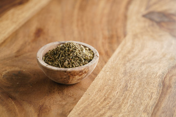 dried provence herb mix in wood bowl for seasoning on table