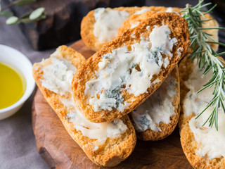 Italian toasts with gorgonzola cheese on rustic background with wine