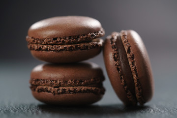 three chocolate macarons on slate board