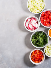 Mix of vegetable bowls for salad or snacks on gray background. Diet detox concept