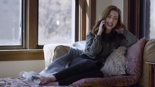 Young Woman Relaxes At Home And Answers A Phone Call