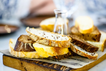The different slices of bread with grains are on the Board and olive oil.