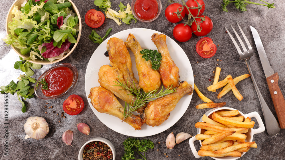 Wall mural grilled chicken leg with salad and french fries