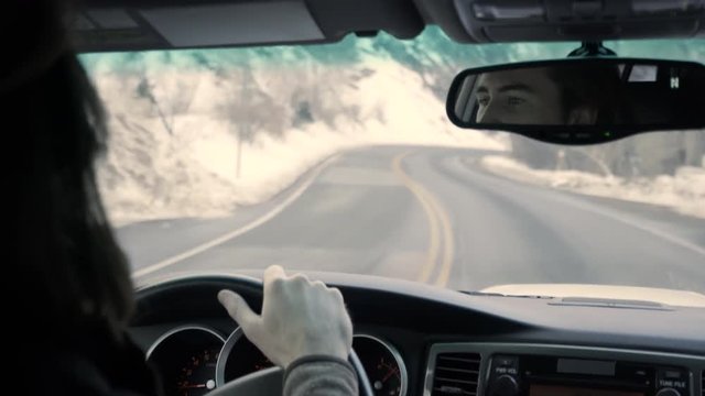 Young Man Drives Up Canyon Road In Snowy Utah Mountains