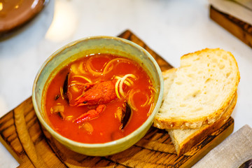 Tomato soup with crayfish and other seafood in the plate.