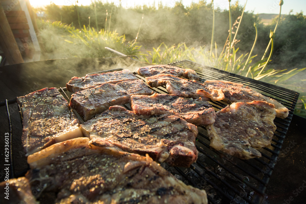 Wall mural Close up wide angle view of meat on the braai / barbeque as a traditional meal in south africa