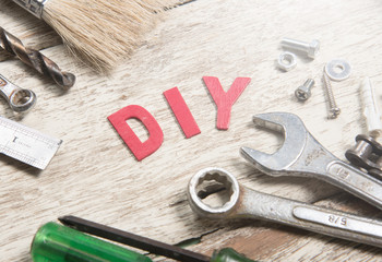 DIY,DO IT YOURSELF word made from wooden letters with set of tools on wood background