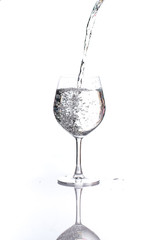 pouring water into a glass wine on white background