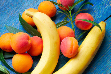 Fresh apricots and bananas on blue background © slawavorster