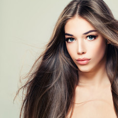 Fototapeta premium Fashion Beauty Portrait of Cute Woman with Long Brown Hair. Makeup, Hairstyle and Cute Face. Beauty Salon Background