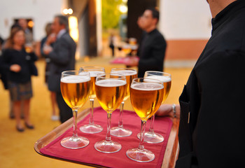 Obraz premium Waiter with cold beer glasses on tray