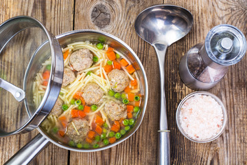 Fototapeta na wymiar Vermicelli soup with meatballs on wooden background