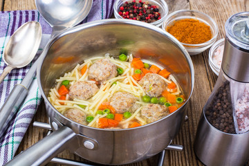 Vermicelli soup with meatballs on wooden background