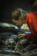 Fototapeta na wymiar Female mechanic inspecting car engine