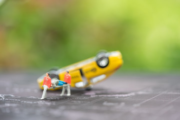 Miniature people, emergency medical team at work at accident scene, car crash, on world map. Concept of health care, emergency, life insurance, accident background