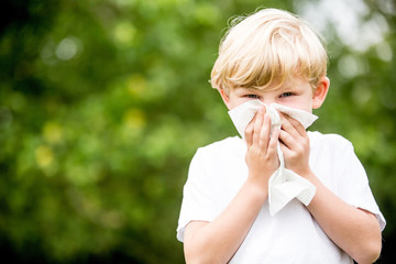 Kind mit Allergie beim Nase putzen