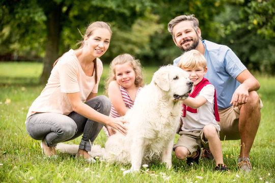 Glückliche Familie mit Hund im Garten