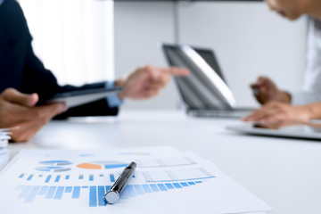 Business people working together and using digital  tablet at a workplace, selective focus