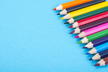 Stationery: colored pencils on blue background. 