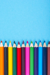 Stationery: colored pencils on blue background. 