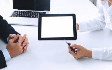 Business people working together and using blank screen digital  tablet at a workplace