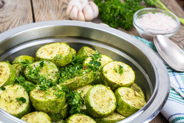 Warm salad with young zucchini with herbs and garlic in metal bo