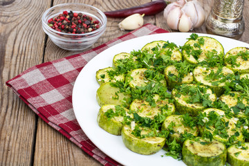 Baked vegetables: zucchini, eggplant on plate on wooden table. V