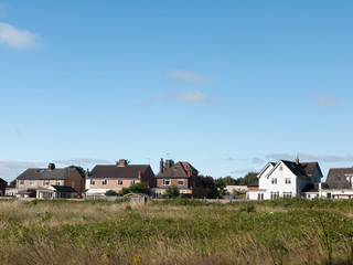 Fototapeta na wymiar Stock Photo - back of houses in a field in summer light wivenhoe essex england uk