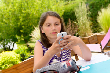 Pre teenager girl texting on mobile phone