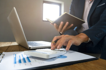 businessman using calculator analyzing on company profits at a modern office