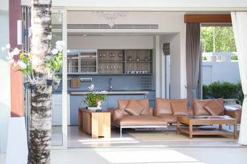 Luxury interior design in livingroom of pool villas. Airy and bright space with high raised ceiling and wooden dining table