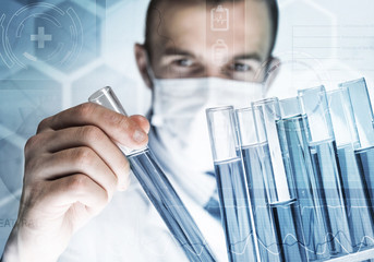 Young scientist mixing reagents in glass flask in clinical laboratory