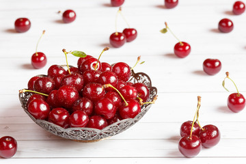 Naklejka na ściany i meble Fresh cherry on plate on wooden background. fresh ripe cherries