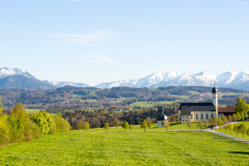Landscape in Bavaria, Germany, church with mountains in the background